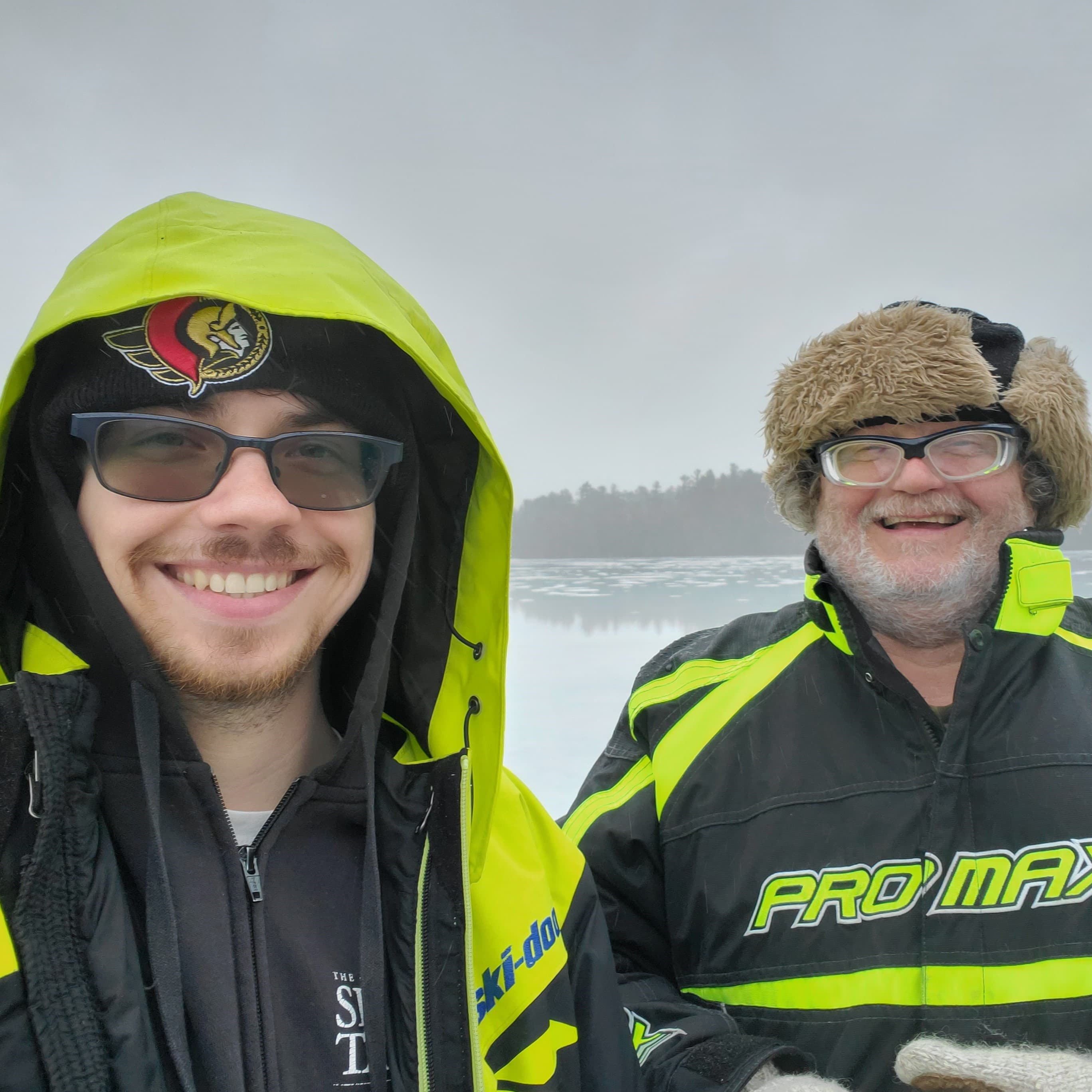 Paul and his dad in winter jackets on a frozen lake ic fishing
